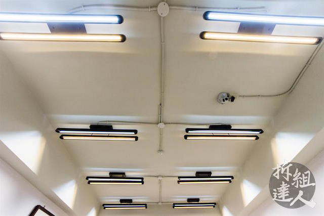 天花裸露處理與黑色線型燈具對稱排列設計